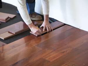 Hardwood planks being laid over a vapor-retarding underlayment after the subfloor passed its moisture readings