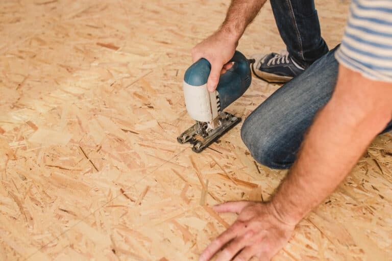 Wood subfloor panels being cut and fitted before a new floor goes down in a New Orleans home