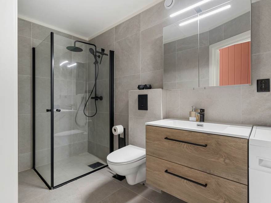 Tiled bathroom floor running under a walk-in shower
