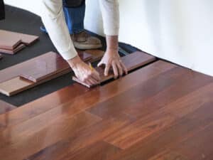 Hardwood planks being laid over a vapor-retarding underlayment after the subfloor passed its moisture readings